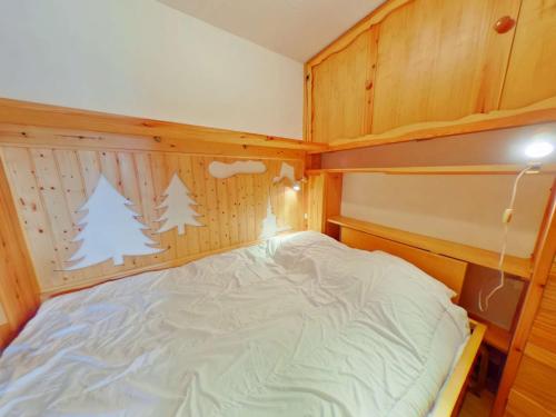 une chambre avec un lit dans une pièce aux murs en bois dans l'établissement Studio cabine cosy avec balcon, proche télésièges et commerces, 5 couchages - Les Saisies - FR-1-594-315, à Hauteluce
