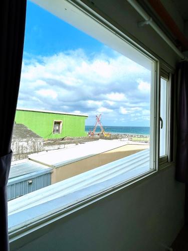 a window with a view of a construction site at White&Light B&B in Manzhou