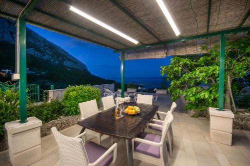 a table and chairs on a patio with a view of the ocean at Holiday Home Vrcani in Veliko Brdo