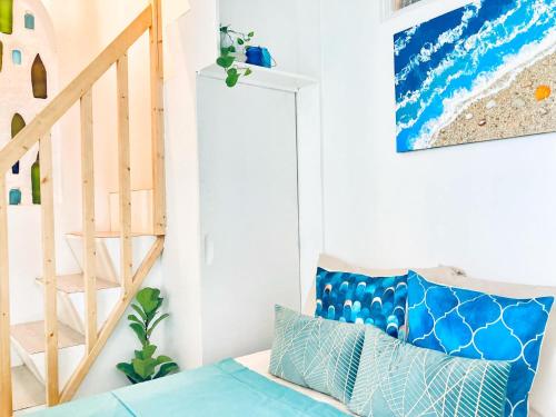 a room with a staircase and a blue couch at Balai Lawaan Charming Sanctuary in Iloilo City