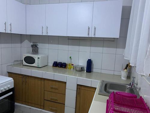 a kitchen with a microwave and a sink at Peaceful Haven in Eldoret