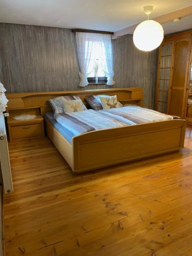 1 dormitorio con 1 cama grande y suelo de madera en Basler Ferienwohnung, en Offenburg