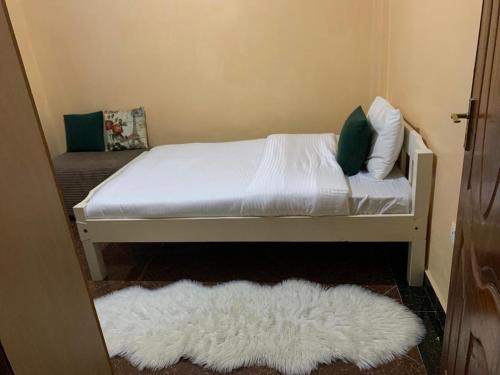 a bedroom with a white bed and a white rug at Peaceful Haven in Eldoret