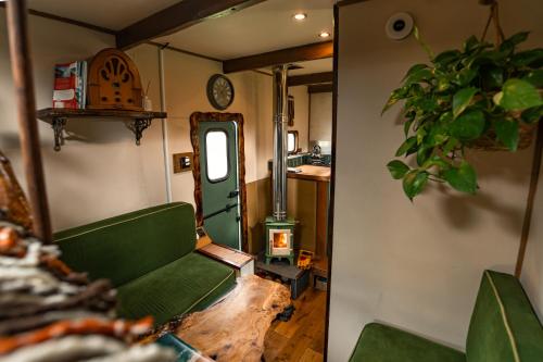 a living room with a green couch and a clock at Vintage '79 Bedford Wild Camping Truck near St Ives in Tuckingmill