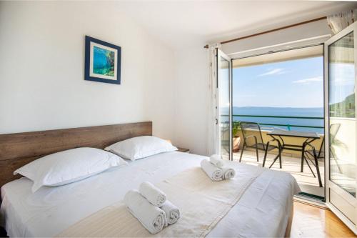Veliko BrdoにあるHoliday Home Vrcaniのベッドルーム1室(ベッド1台付)、海を望むバルコニーが備わります。
