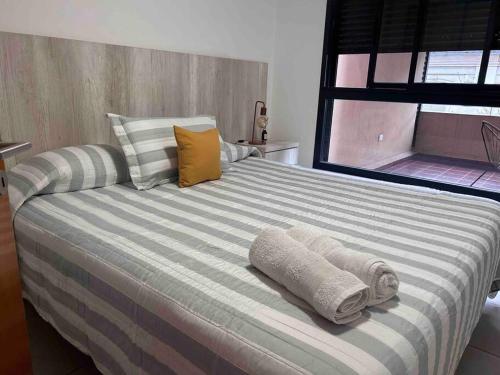 - une chambre avec un grand lit et des serviettes dans l'établissement Oasis urbano para 3 personas: terraza y piscina en Córdoba, à Córdoba