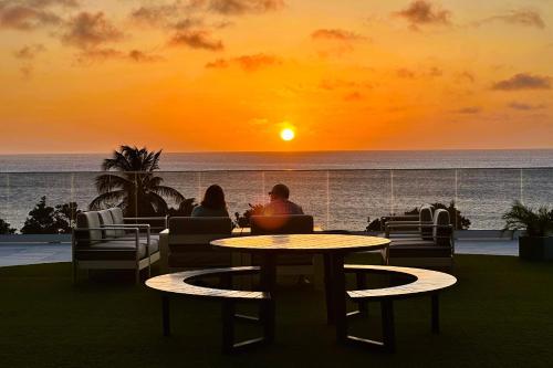 a couple sitting at a table watching the sunset at O Condominium Beachfront Residences, by Bocobay Aruba in Palm-Eagle Beach