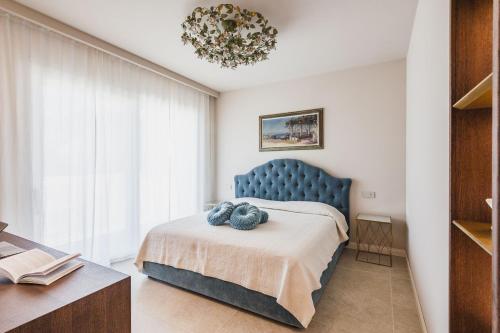 a bedroom with a blue bed and a chandelier at 5E Villa Charme-Sea and Ortigia view-Whirlpool roof Terrace in Siracusa