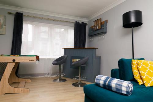 a living room with a couch and a ping pong table at Harmony Haven Executive Suite in Nottingham