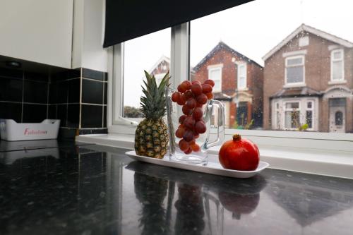 a plate of fruit on a counter next to a window at Harmony Haven Executive Suite in Nottingham