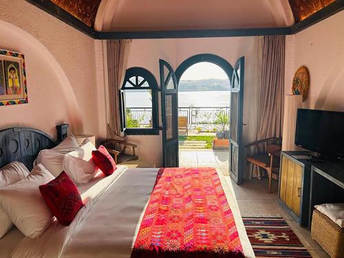 Un dormitorio con una cama grande y una ventana en Sonesta Nouba Hotel Aswan en Asuán