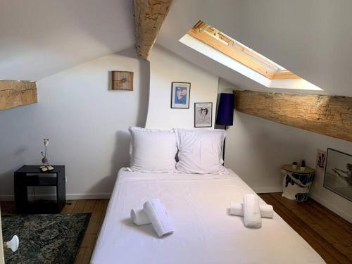 a bedroom with a large white bed with white pillows at Maison de caractère avec jardin arboré en Avignon in Avignon