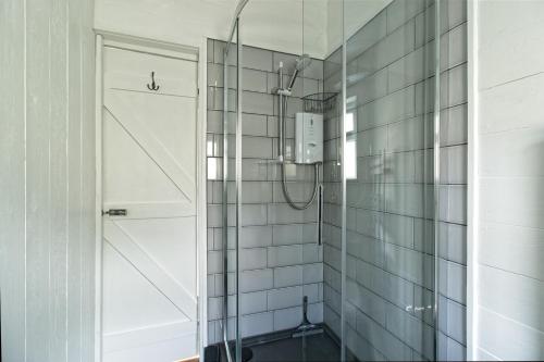 a bathroom with a shower with a glass door at Isle of Wight Cabin in Newtown