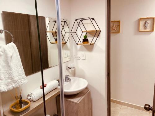 a bathroom with a sink and a mirror at Apartamento Exclusivo - Caribe Campestre Coveñas in Coveñas