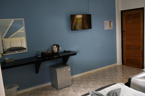 Habitación con pared azul, mesa y espejo. en DolceVita Wonderful Resort en Ko Lanta