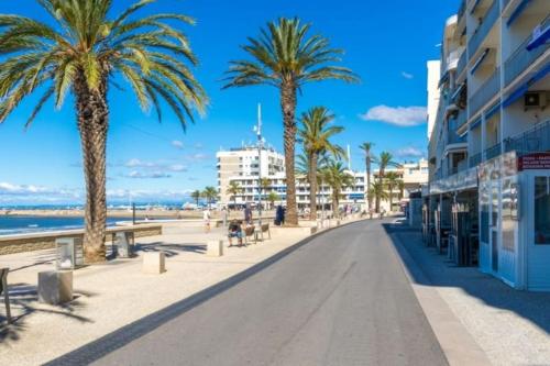 una calle junto a la playa con palmeras y edificios en Studio en Petite Camargue en Le Cailar