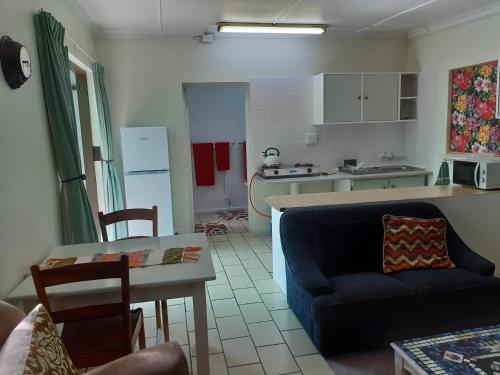 a kitchen and a living room with a couch and a table at Rosies in George