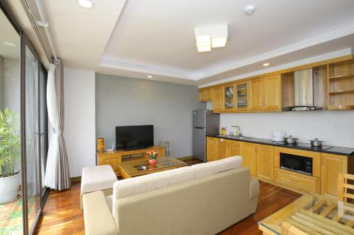 a living room with a couch and a kitchen at Investland in Truc Bach & serviced apartment in Hanoi