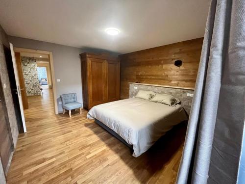 a bedroom with a bed and a wooden wall at Nouveau appartement 12 personnes - chez mon boucher - in Rouffach