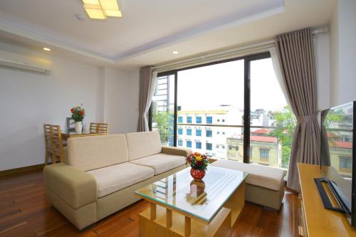 a living room with a couch and a large window at Investland in Truc Bach & serviced apartment in Hanoi