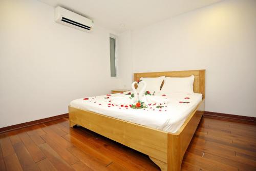a bedroom with a bed with flowers on it at Investland in Truc Bach & serviced apartment in Hanoi
