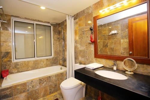 a bathroom with a sink and a tub and a toilet at Investland in Truc Bach & serviced apartment in Hanoi