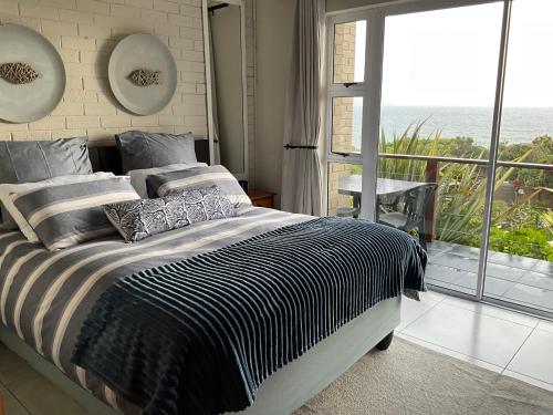 a bedroom with a bed with a view of the ocean at Bloudam Wilderness in Wilderness