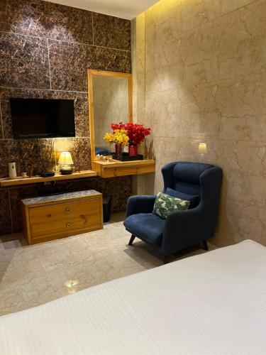 a bedroom with a bed and a chair and a mirror at Divine Studios Rajouri Garden in New Delhi