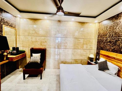 a bedroom with a bed and a chair at Divine Studios Rajouri Garden in New Delhi
