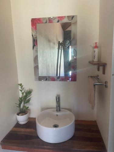 La salle de bains est pourvue d'un lavabo blanc et d'un miroir. dans l'établissement Mai Chau Hillside Homestay, à Mai Châu
