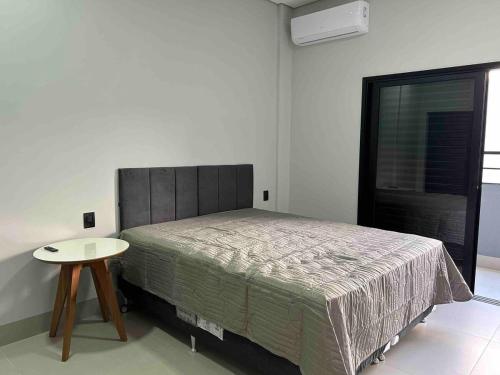 Un dormitorio con una cama y una mesa. en Studios Mobiliados - Ambar Ipanema, en Sinop