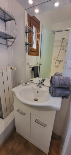 een badkamer met een witte wastafel en een spiegel bij Studio meublé avec terrasse in Gréoux-les-Bains