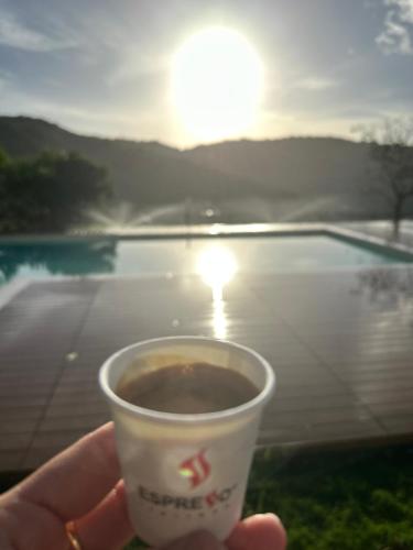 a person holding a cup of coffee in front of a pool at Villa Le Torrette in Agropoli