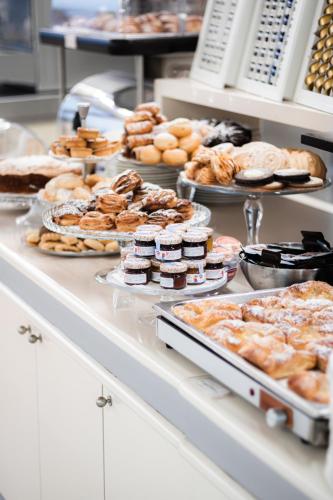 a buffet filled with different types of pastries and desserts at Hotel Desenzano in Desenzano del Garda
