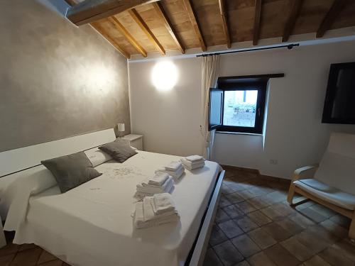 a bedroom with a white bed with towels on it at Casa Vacanze Porta di Valle in Bagnoregio