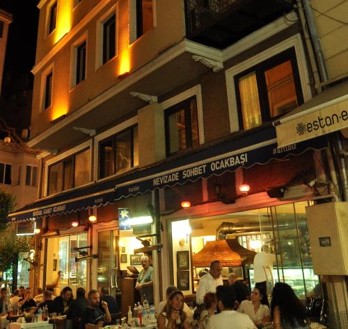 un grupo de personas sentadas fuera de un restaurante por la noche en Grand Hisar Hotel, en Estambul