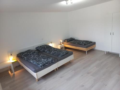deux lits jumeaux dans une chambre avec deux lampes dans l'établissement hoteliving Düsseldorf Airport, à Ratingen