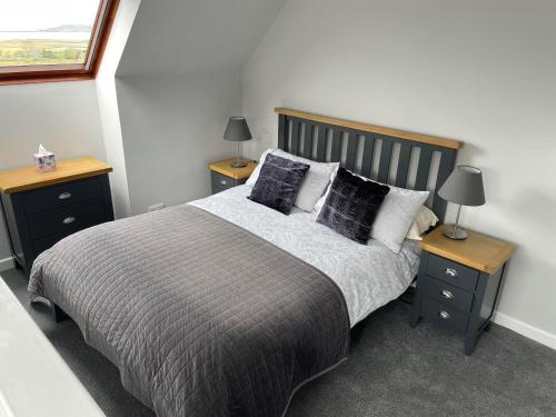1 dormitorio con 1 cama grande y 2 mesitas de noche en Ruisgarry Bed and Breakfast, en Breakish