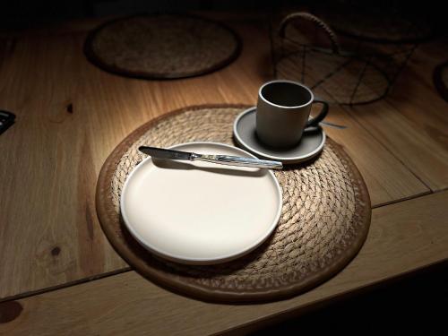 a plate with a coffee cup on a table at Ferienwohnung Seemöwe in Emden