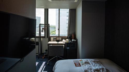 a bedroom with a bed and a desk and a window at Wander Tokyo Shibuya in Tokyo