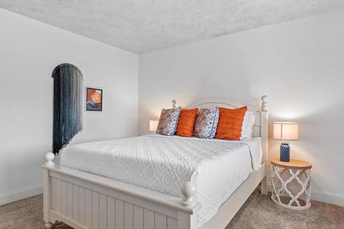 a bedroom with a white bed with orange pillows at Modern Home-Garage-Scenic Patio in Rapid City