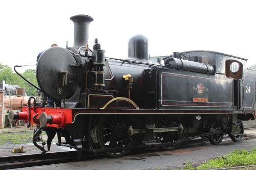 a black train is sitting on the tracks at Driftwood Heart in Freshwater