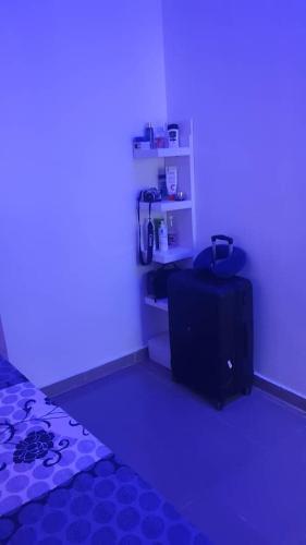 een kamer met een donkere kamer met een bed en een koffer bij Cozy Home in Akure