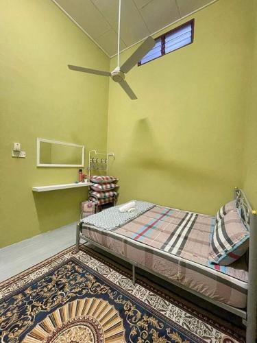 een slaapkamer met een bed in een kamer met een tapijt bij SRI TEGUH HOMESTAY in Tanah Merah