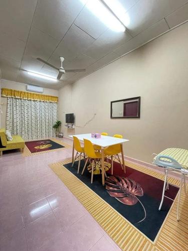 a room with a table and chairs and a tv at SRI TEGUH HOMESTAY in Tanah Merah