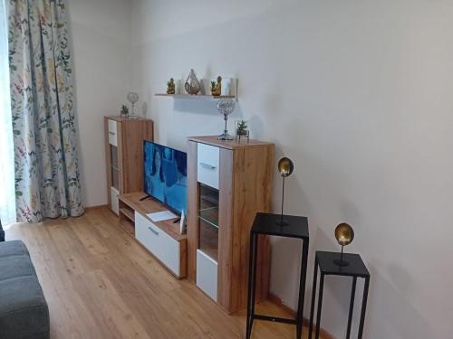a living room with a tv and two end tables at Haus Eichkogel Guntramsdorf in Guntramsdorf