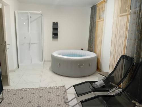 a bathroom with a large tub and a chair at Haus Eichkogel Guntramsdorf in Guntramsdorf