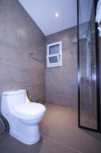 a bathroom with a white toilet and a shower at شقق المبات للشقق المخدومة in Riyadh