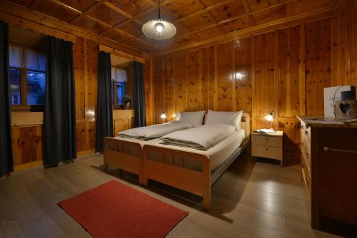 a bedroom with a bed in a room with wooden walls at Bait dal Colocator in Livigno