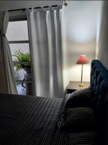 una camera con letto e tavolo con lampada di Dpto Independiente Lanus Oeste a Gerli